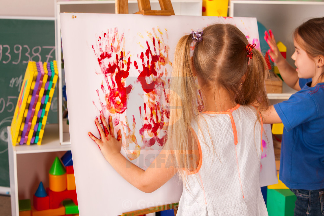 Children Painting Finger On Easel Group Of Kids With Teacher