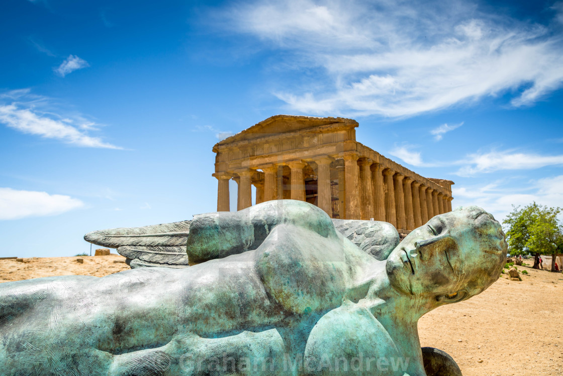 "Icarus bronze statue and Temple of Concordia in the Valley of Temples in Agrigento, Sicily, Italy" stock image