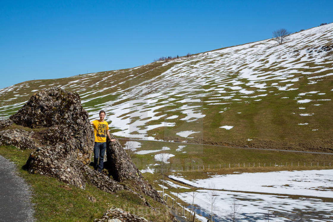 "Young man standing between the rocks in the Alps. Beautiful nature view." stock image