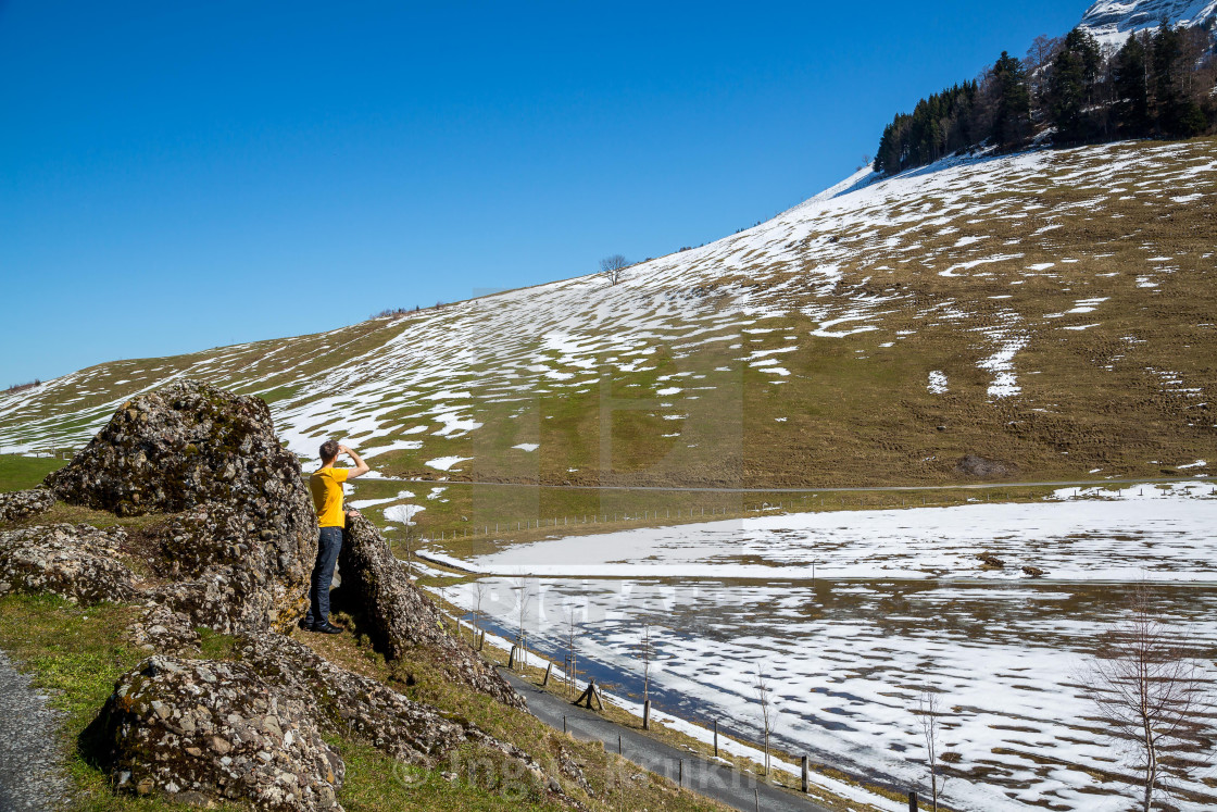 "young man is taking pictures of beautiful nature views in Swiss Alps." stock image