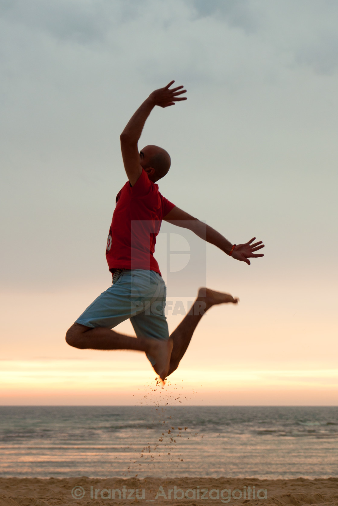 Young man jumping at the beach at sunset. Joyful and funny vacations - License, download or print for £ | Photos | Picfair Young man jumping at the beach at sunset. Joyful and funny vacations - License, download or print for £ | Photos | Picfair