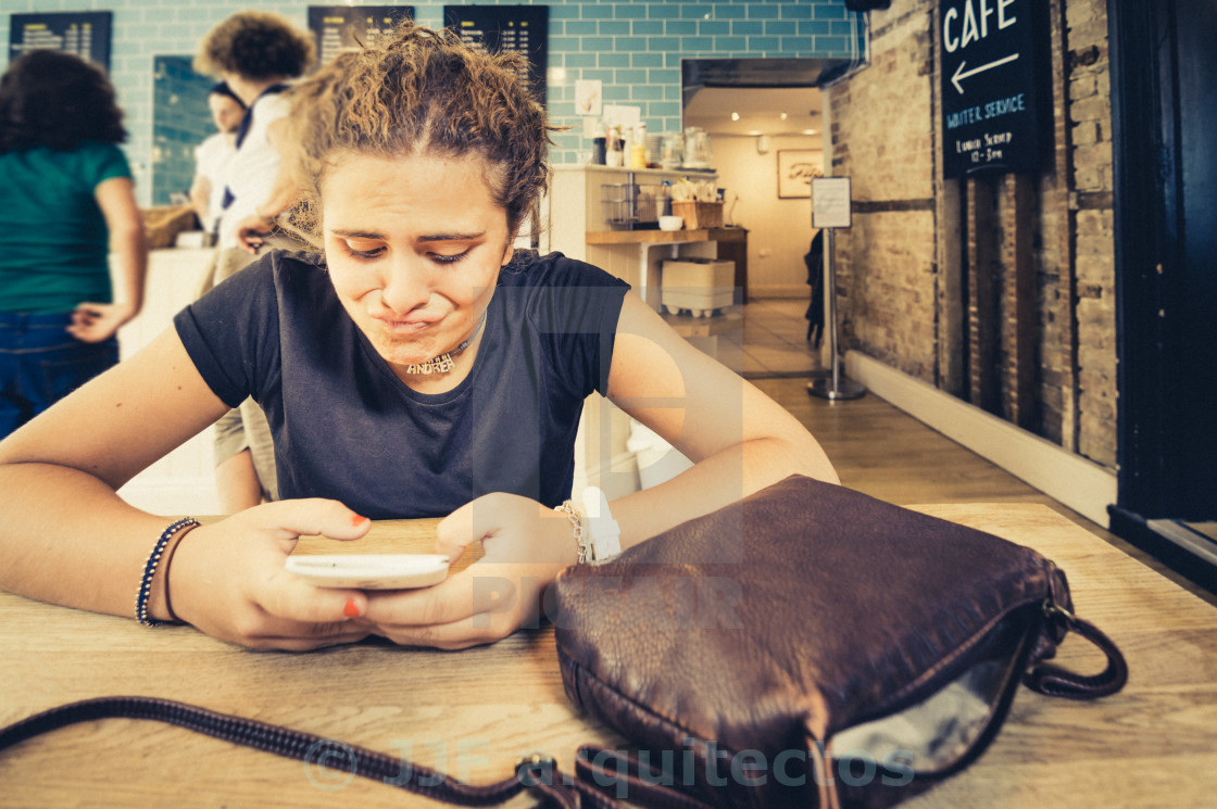 "Young woman watching her smartphone. Weird face" stock image