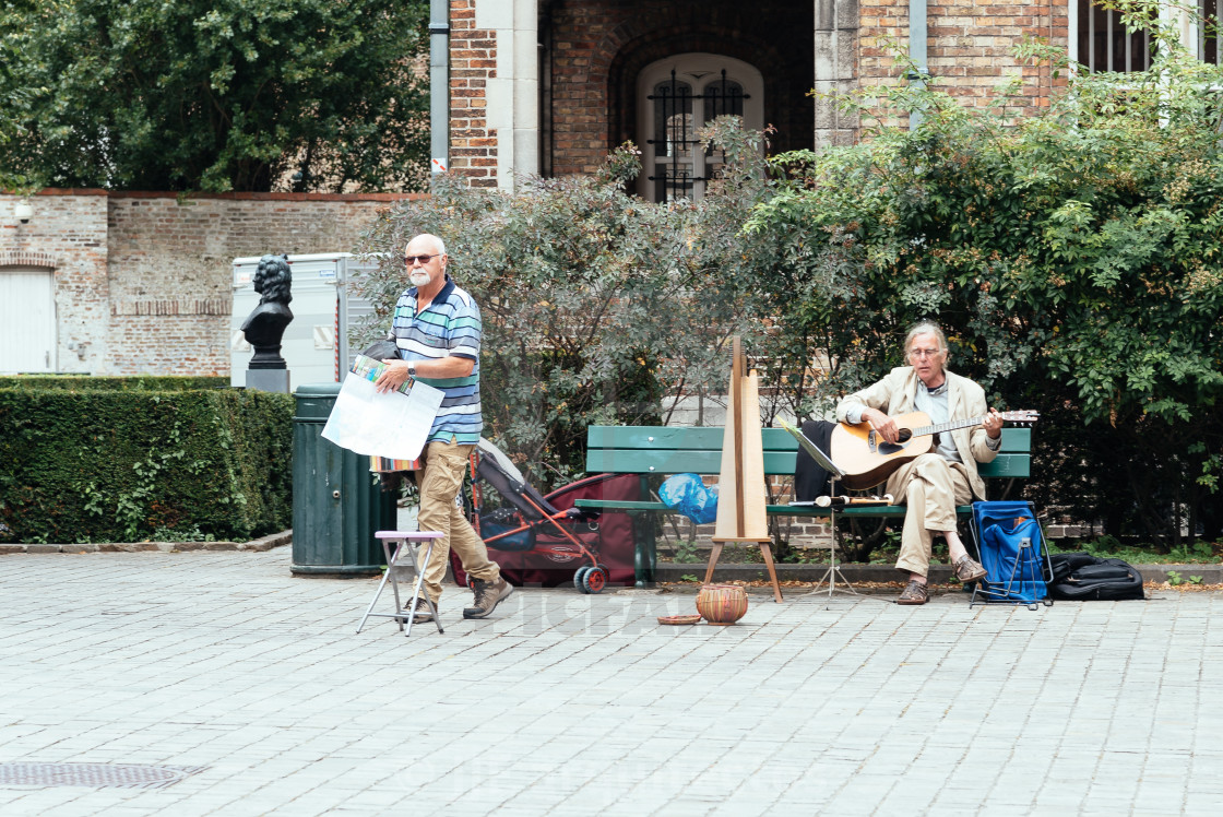 "Musician playing guitar and harp in the streets of Bruges" stock image