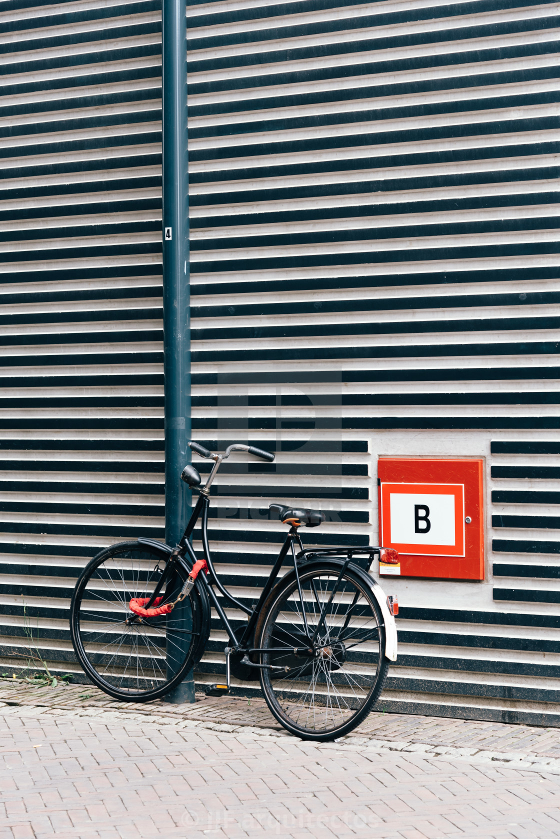 "An old bicycle stands in front of the facade of a modern archite" stock image