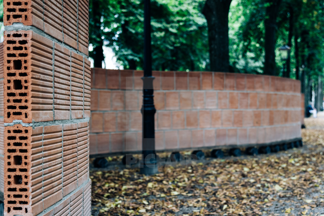 "Curved brick wall in city park, focus on foregtround, space for" stock image