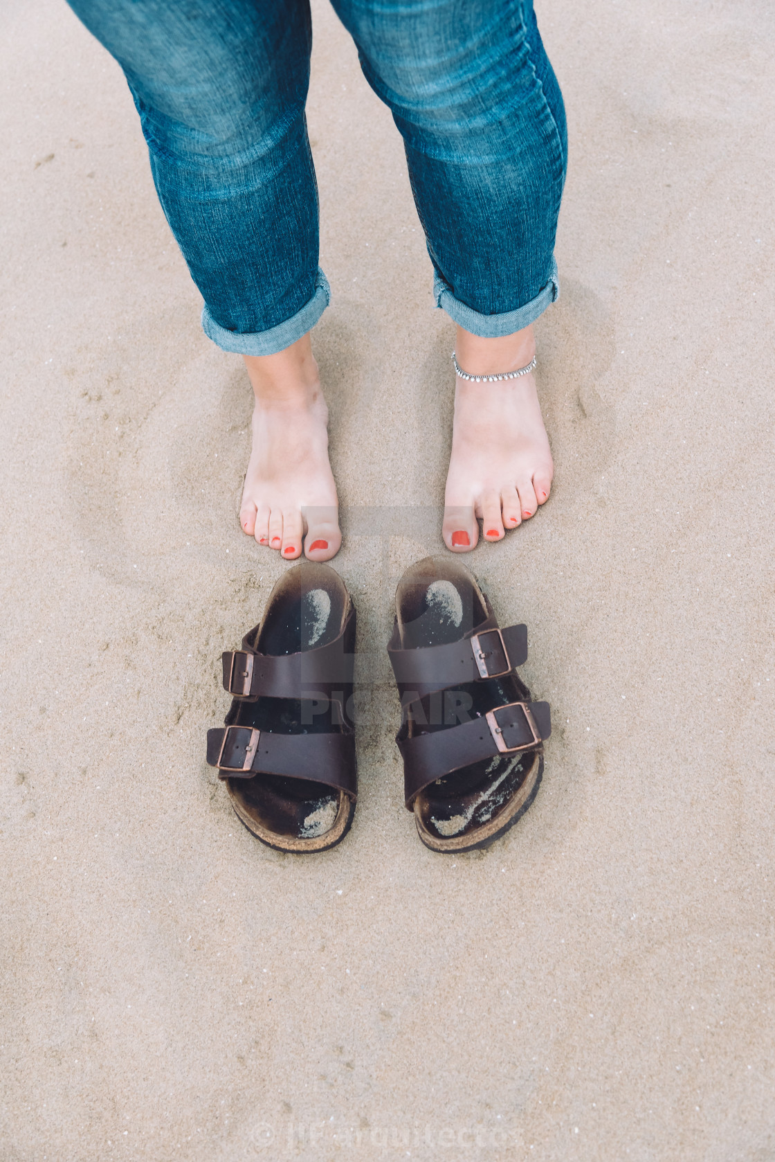 "Barefoot girl on the beach next to her shoes" stock image