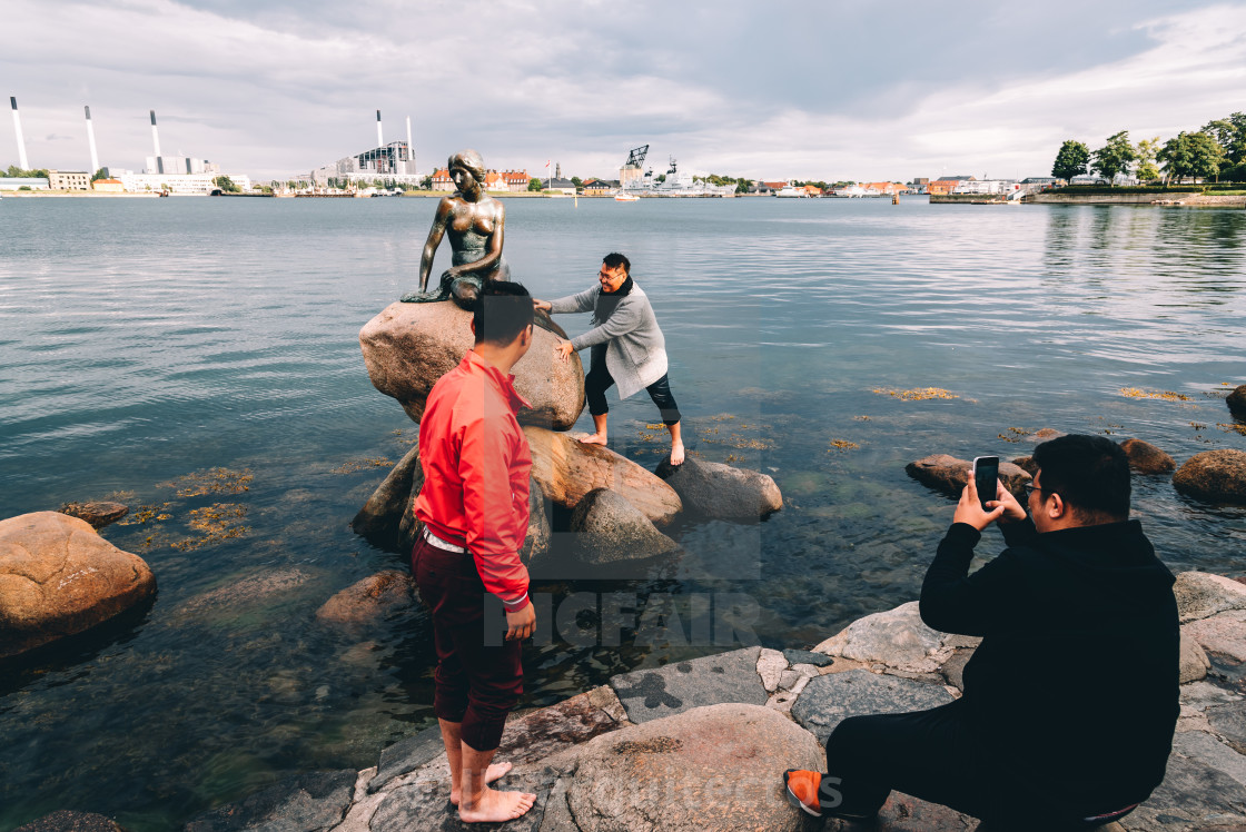 "Some unidentified tourists trying to climb to little mermaid sta" stock image