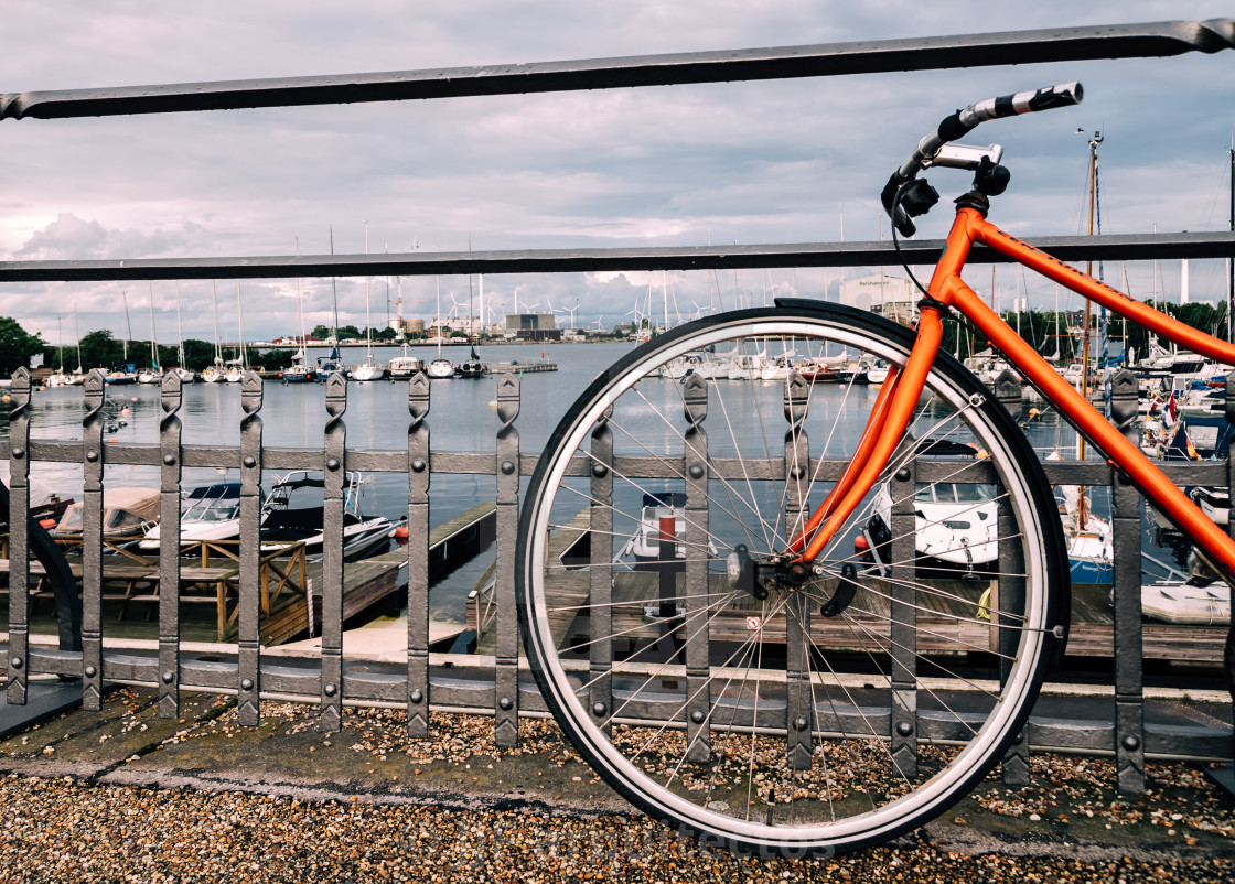 "View through the wheel of a bicycle of private yachts moored in" stock image