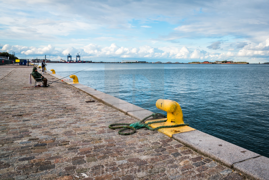 "Fishermen fishing in the port of Copenhagen near sunset." stock image