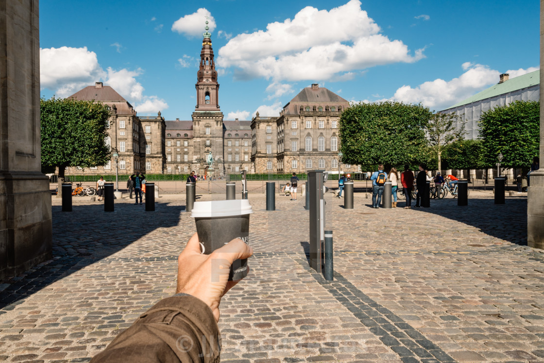 "Man holding a coffee in Copenhagen monument" stock image