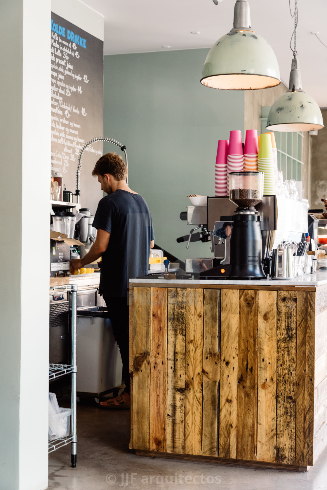 "Man working in a hipster looking coffee shop open for the day wi" stock image