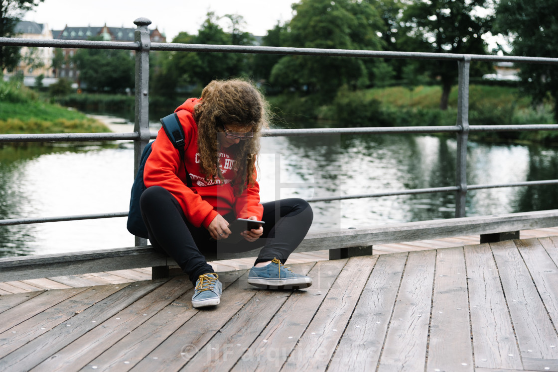 "Young caucasian with curly hair girl using tablet outdoor sitti" stock image