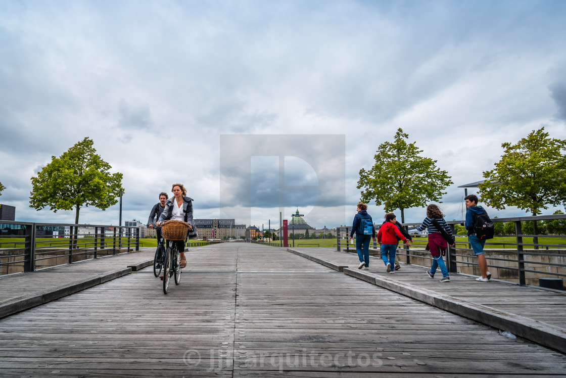 "People crossing a bridge against copenhagen cityscape a cloudy d" stock image