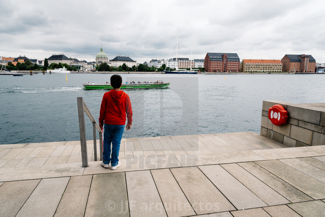 "Unidentified kid in steps of Opera house of Copenhagen a cloudy" stock image