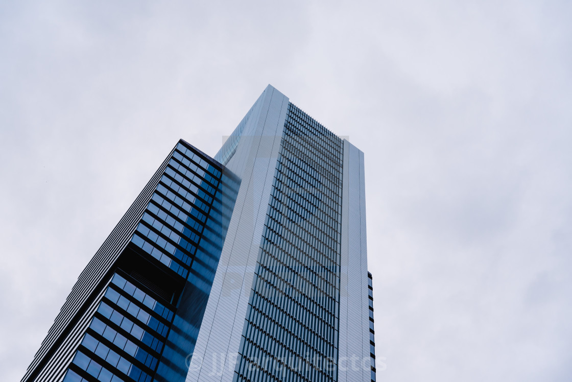 "Low angle view of skyscraper in business district against sky" stock image