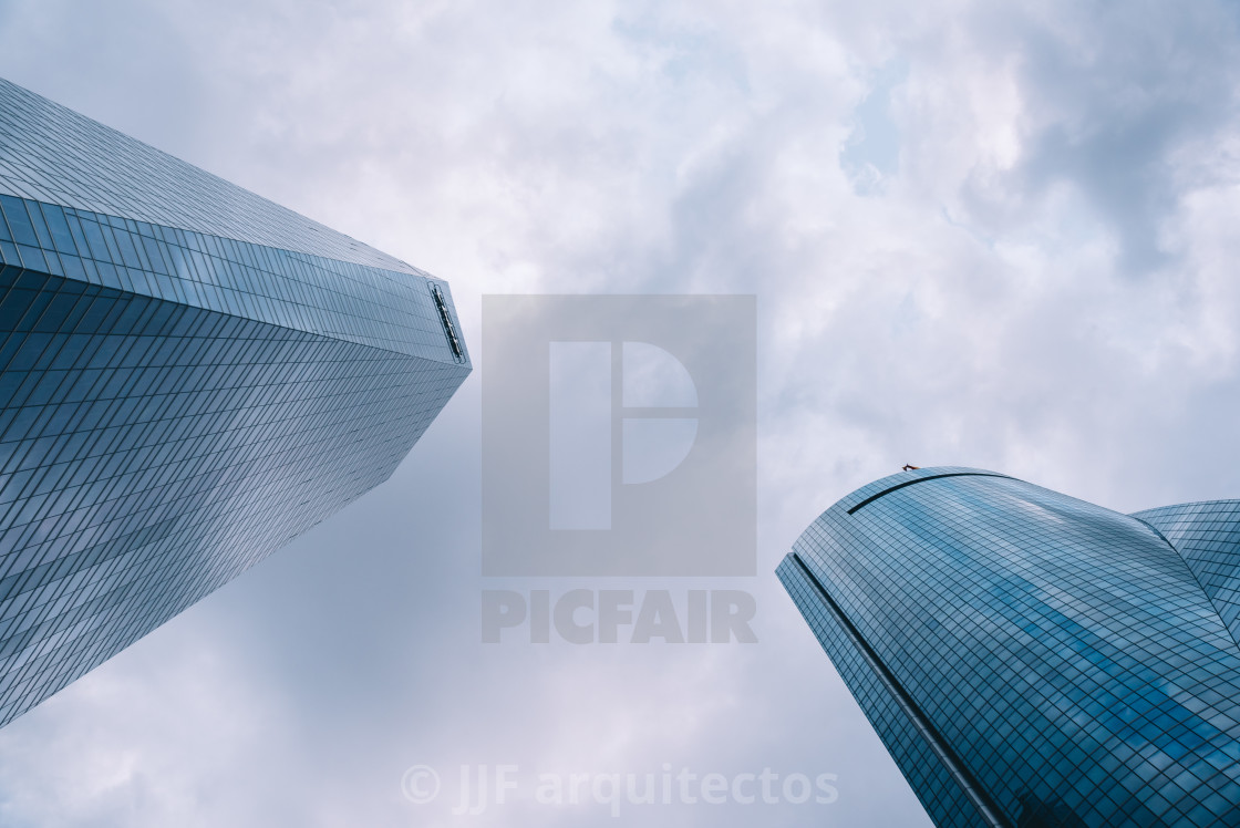 "Low angle view of skyscraper in business district against sky" stock image