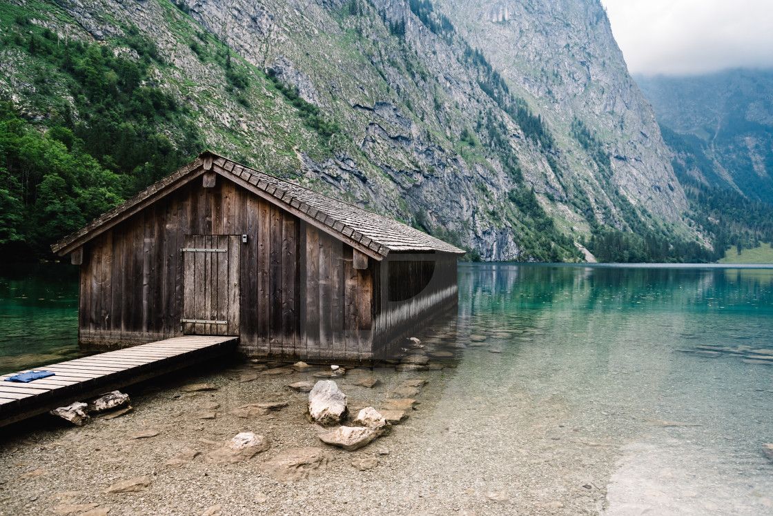 "Wooden cottage in beautiful lake in the Alps with misty mood" stock image