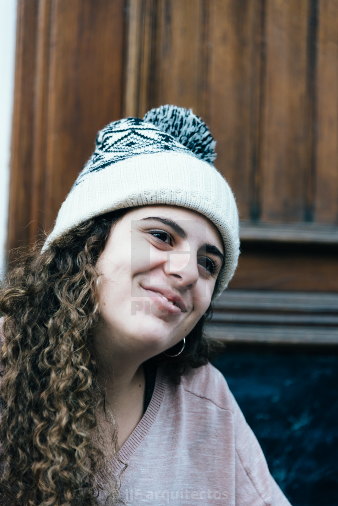 Smiling Teenage Girl With Long And Curly Hair Wearing A Knit Hat