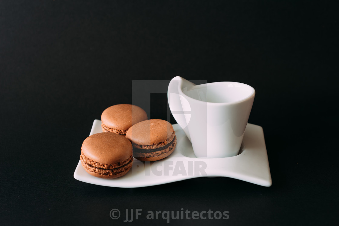 "Set of cup of coffee and macaroons against black background" stock image
