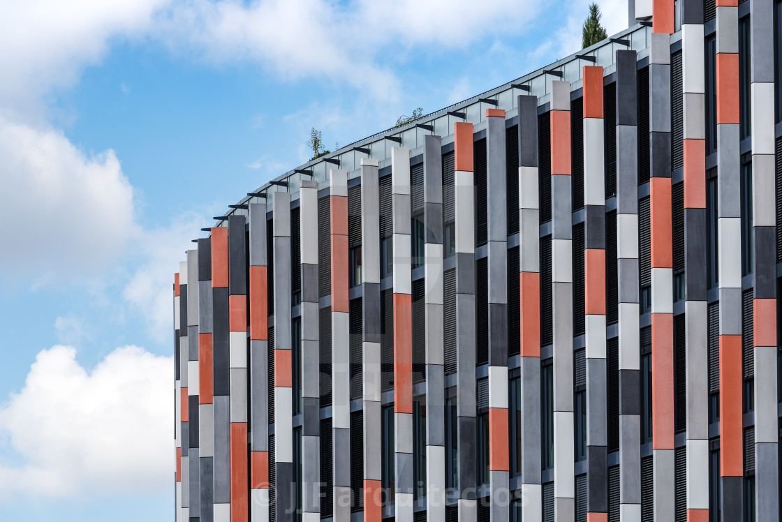 "Low angle view of modern office building against sky" stock image