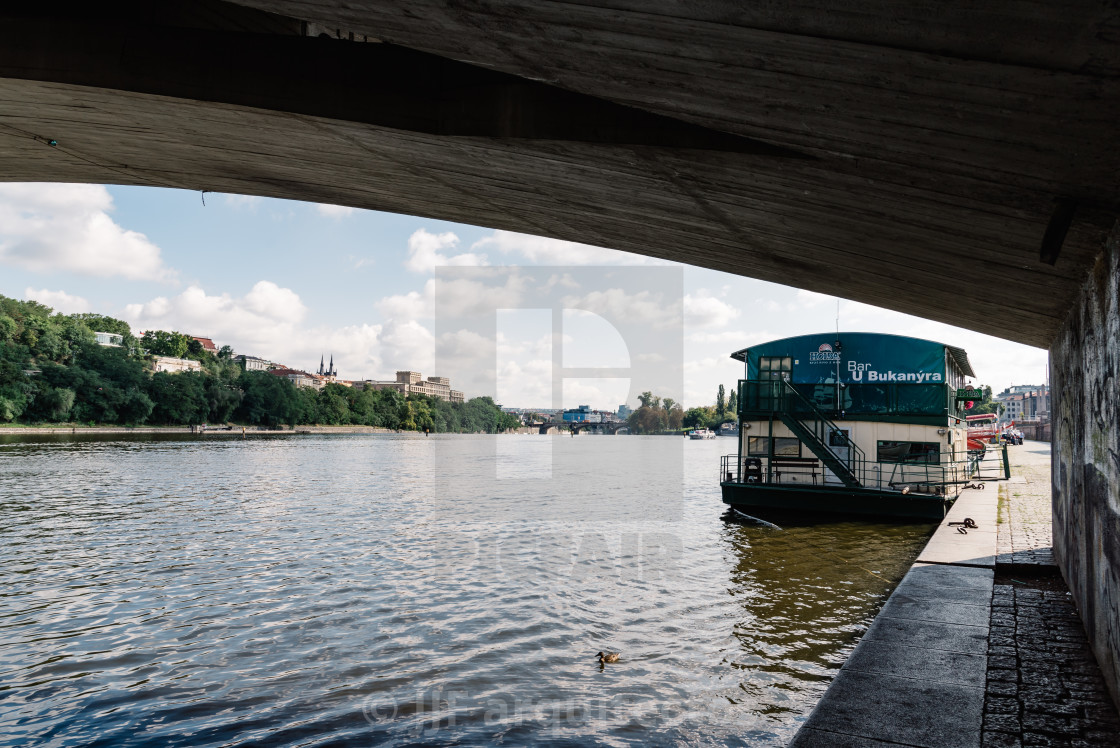 "Touristic boat in Vltava River in Prague against cityscape" stock image