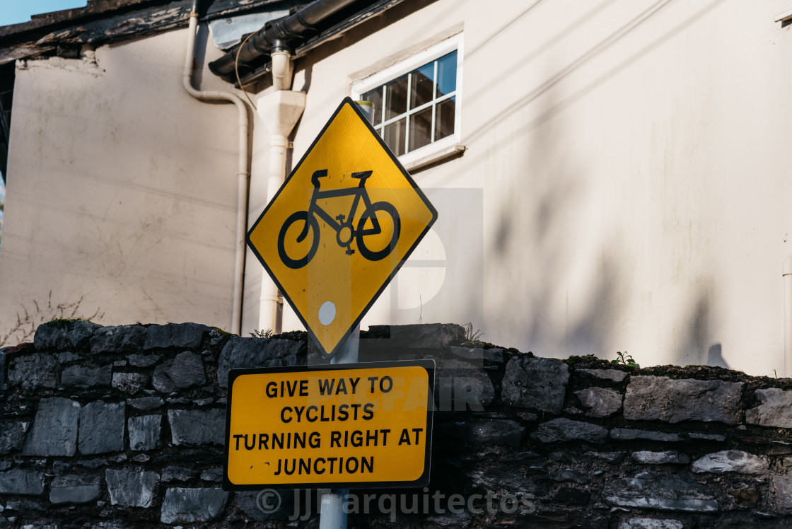 "Yellow warning symbol in street of irish town" stock image