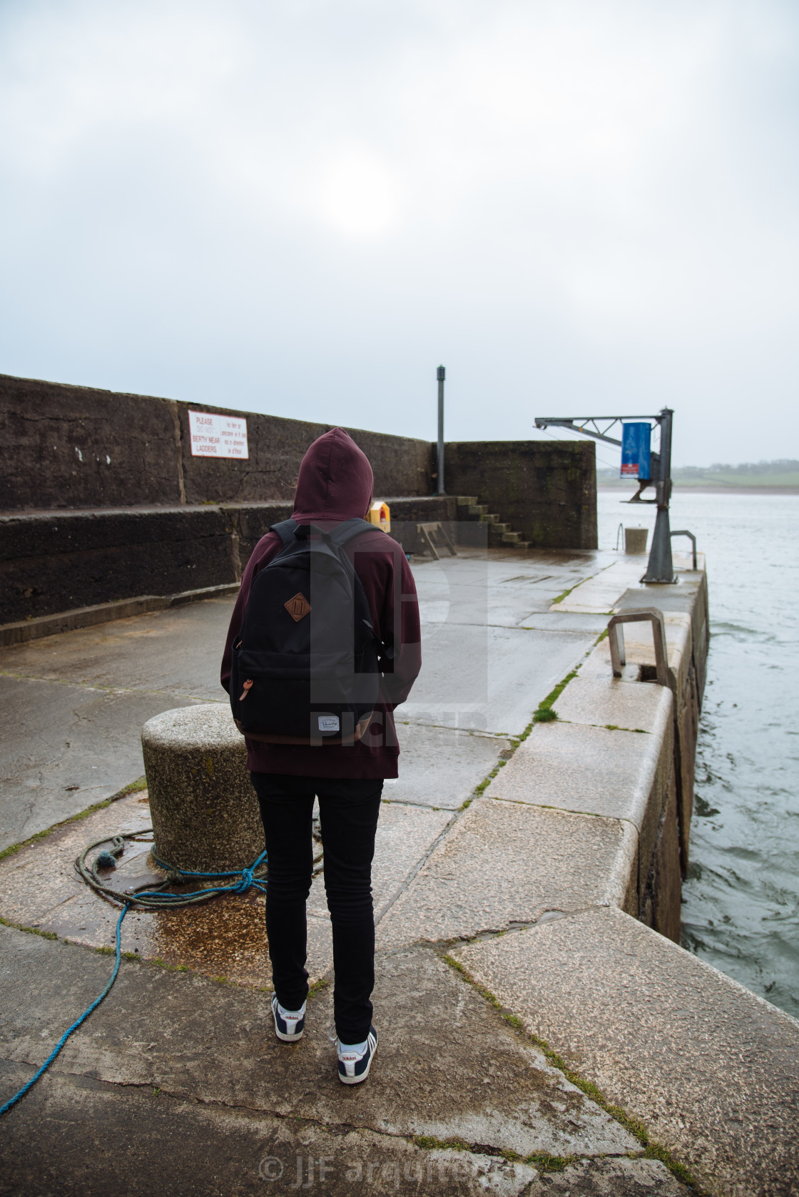 "Woman wearing casual clothes standing at harbor in Irish coast" stock image