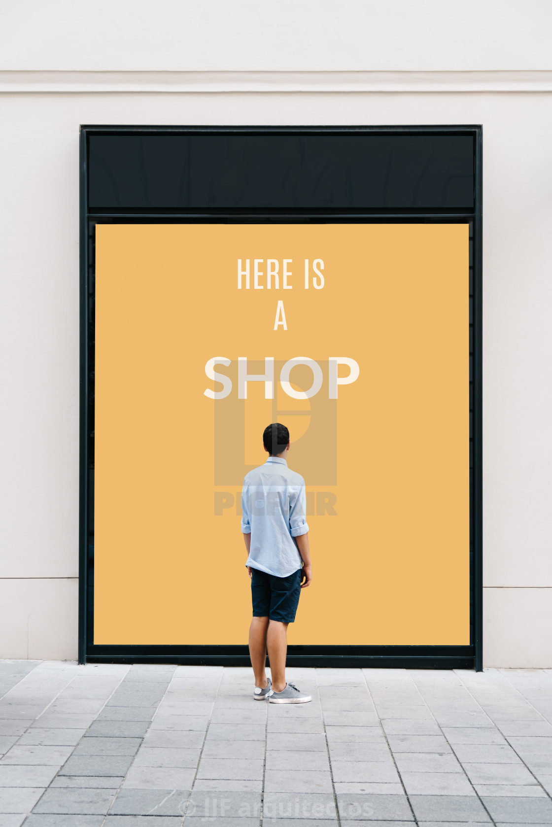 "Young man from behind in front of store showcase" stock image