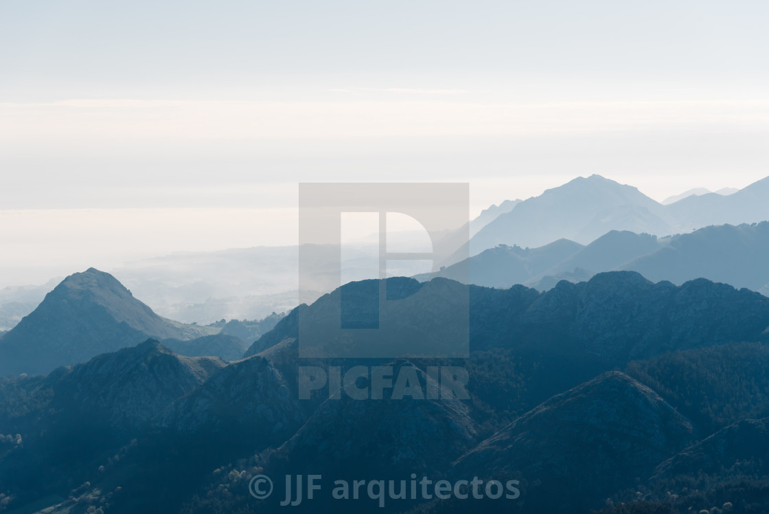 "Scenic view of silhouettes of mountains in the morning mist" stock image