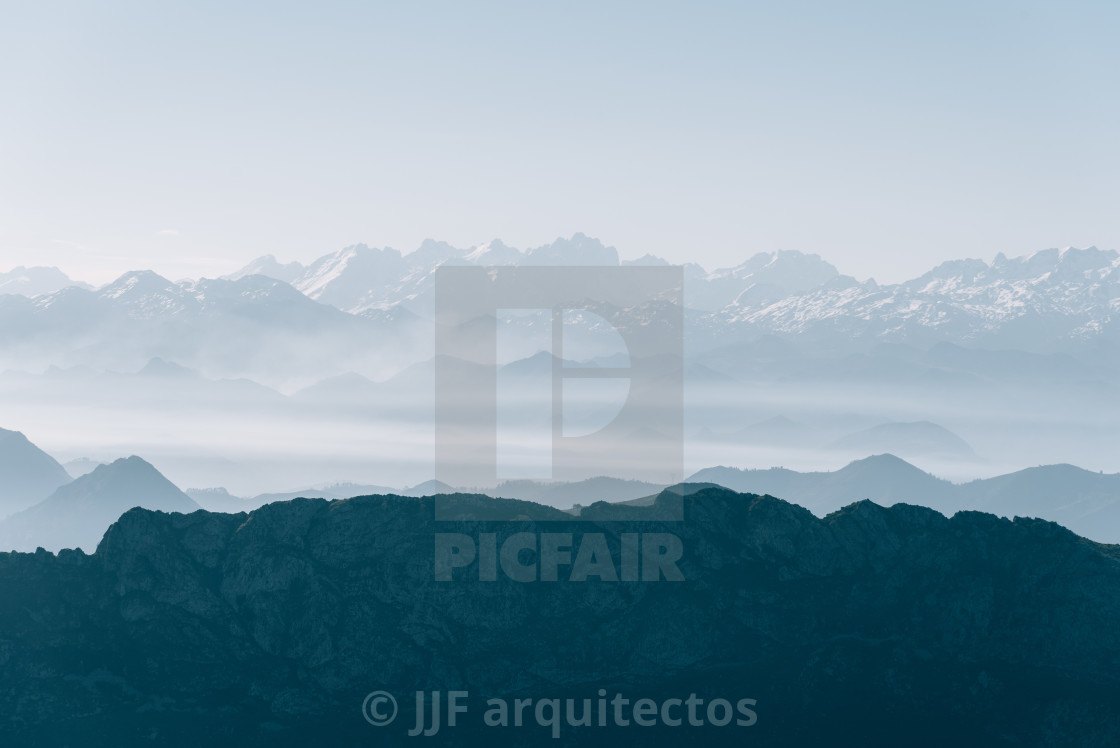 "Scenic view of silhouettes of mountains in the morning mist" stock image