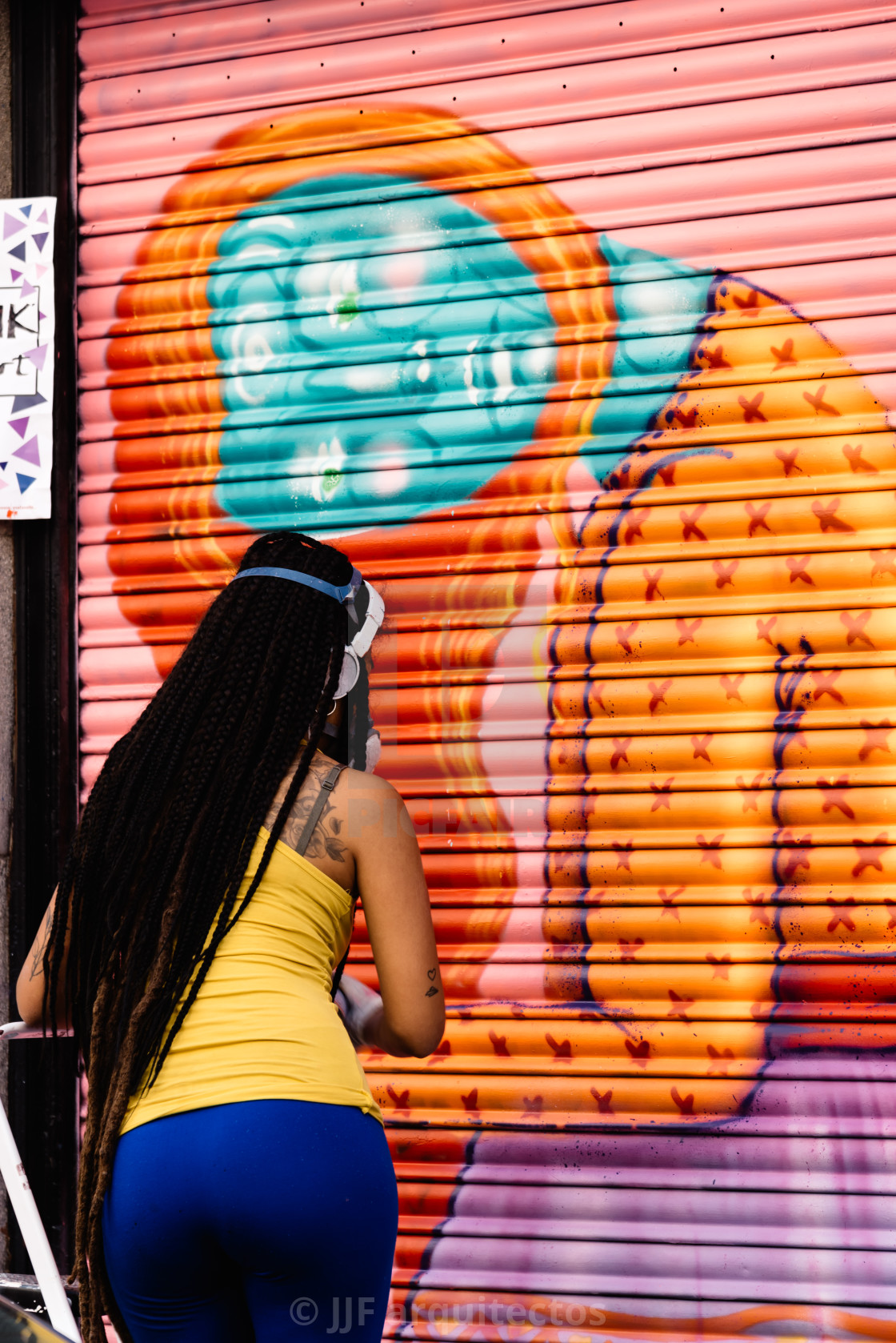 "Artist woman painting storefront in Malasana district in Madrid" stock image