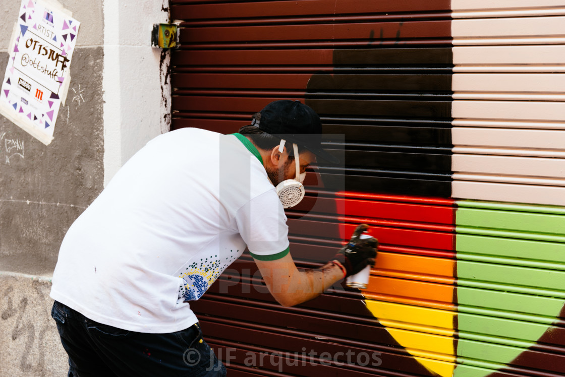 "Artist painting storefront in Malasana district in Madrid" stock image