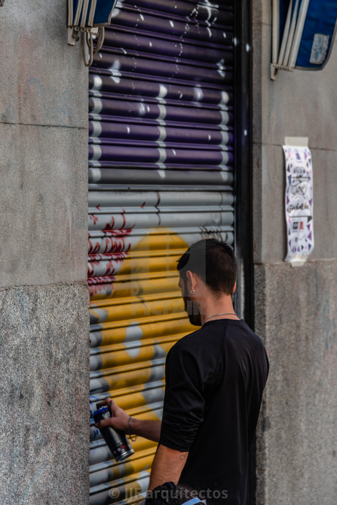 "Artist painting storefront in Malasana district in Madrid" stock image