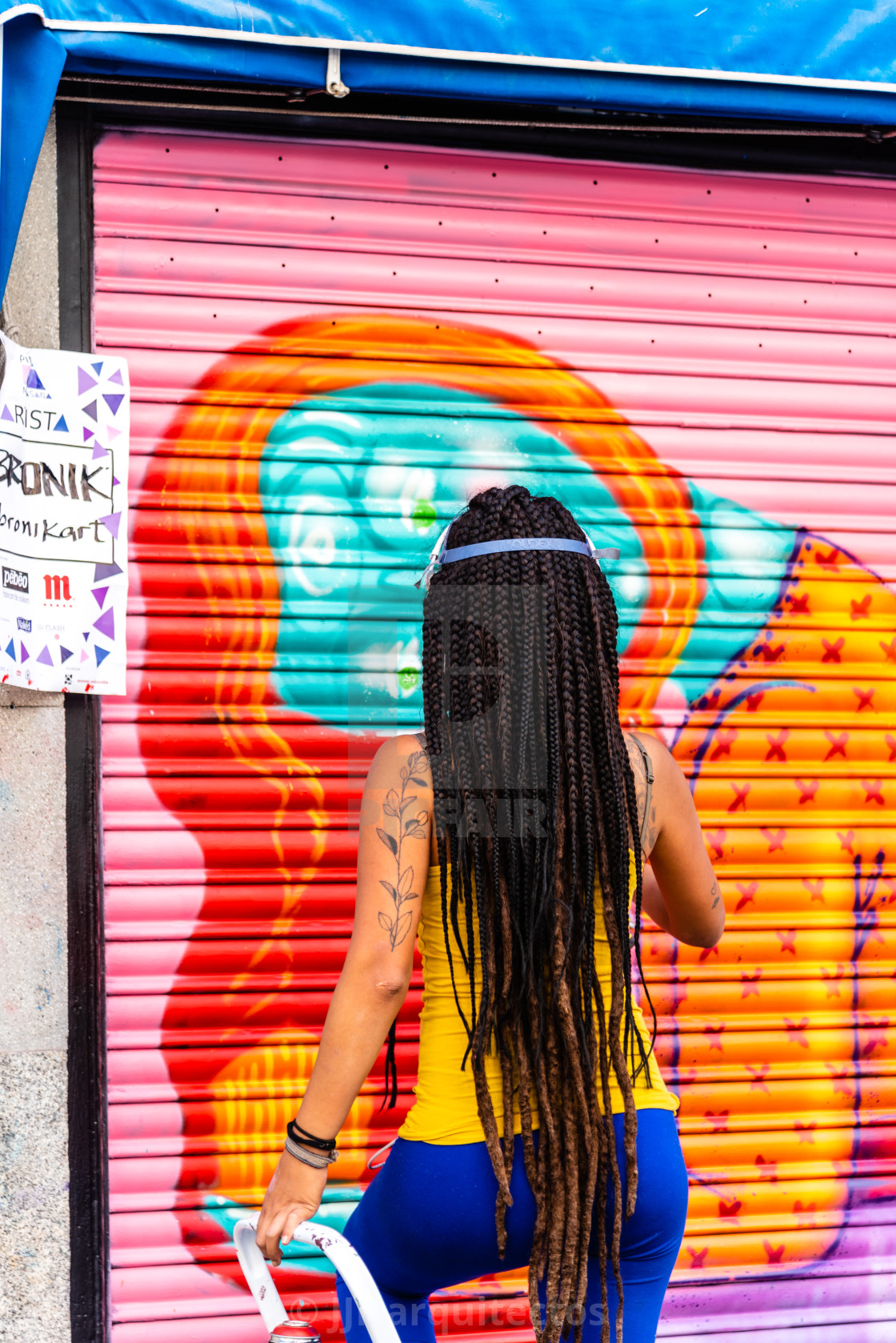 "Artist woman painting storefront in Malasana district in Madrid" stock image