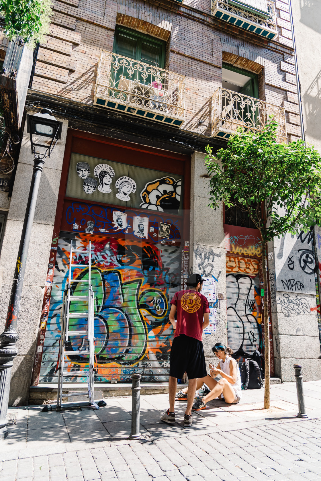 "Artists painting storefront in Malasana district in Madrid" stock image