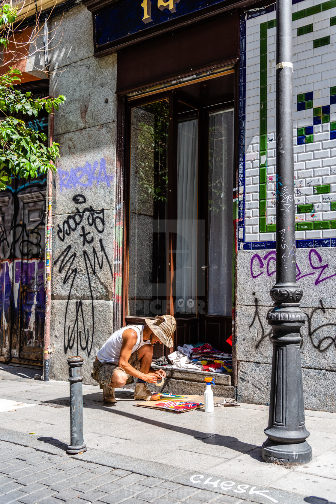 "Artist painting storefront in Malasana district in Madrid" stock image