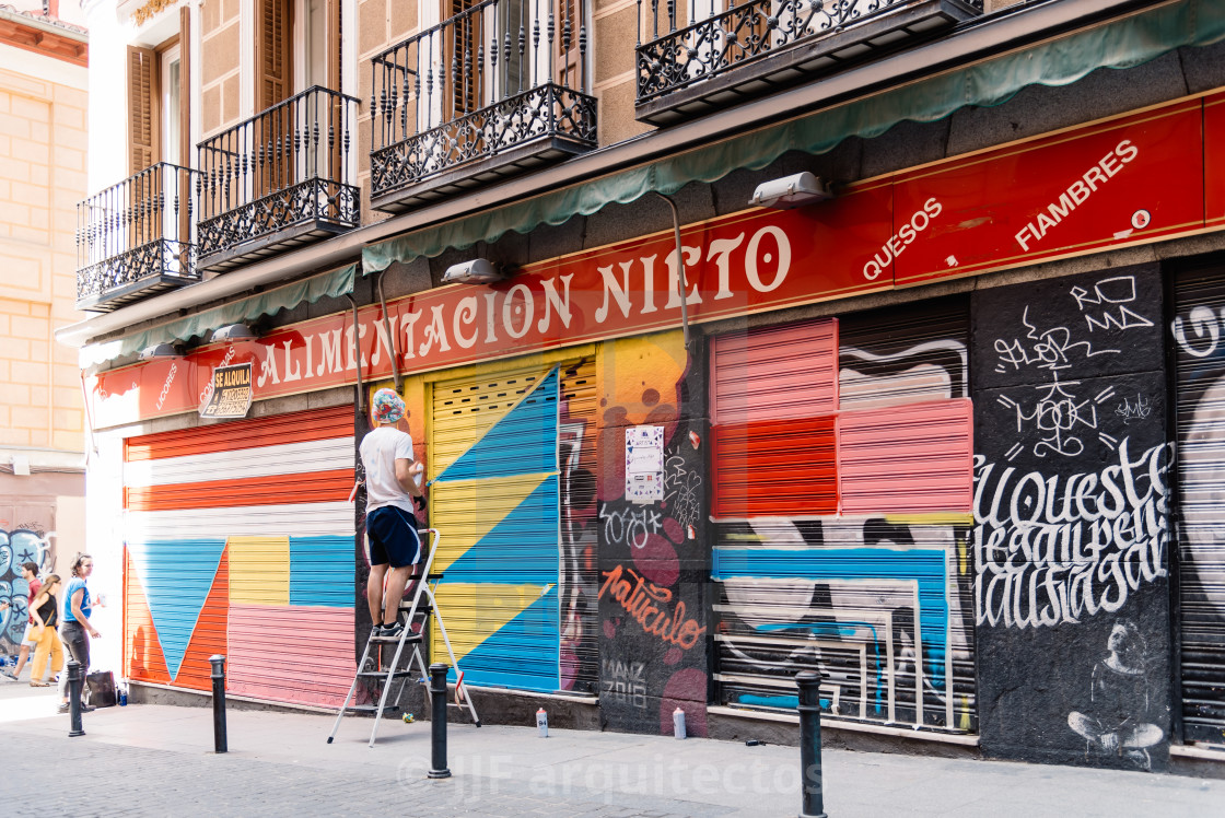 "Artist painting storefront in Malasana district in Madrid" stock image