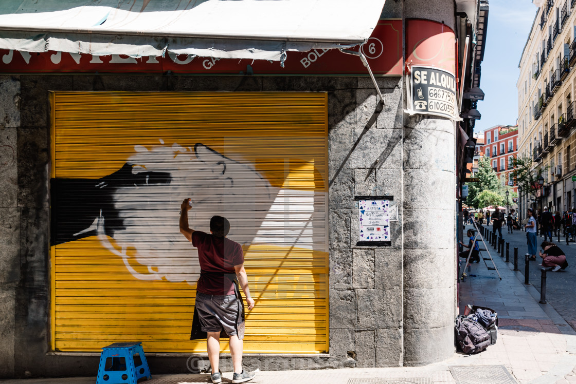 "Artist painting storefront in Malasana district in Madrid" stock image