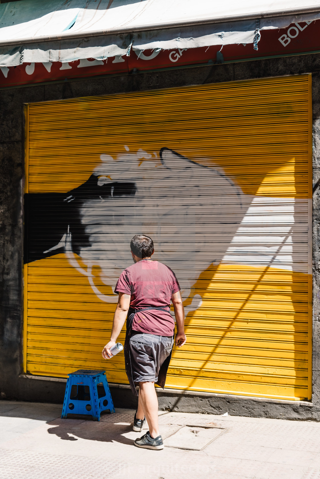 "Artist painting storefront in Malasana district in Madrid" stock image