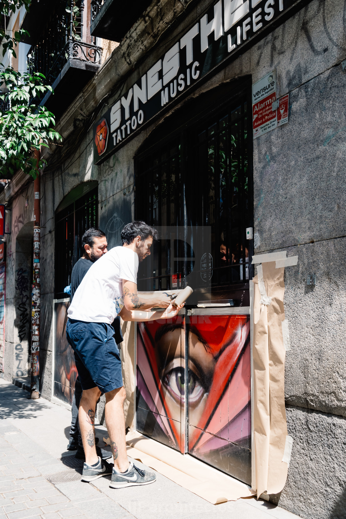 "Artists painting storefront in Malasana district in Madrid" stock image