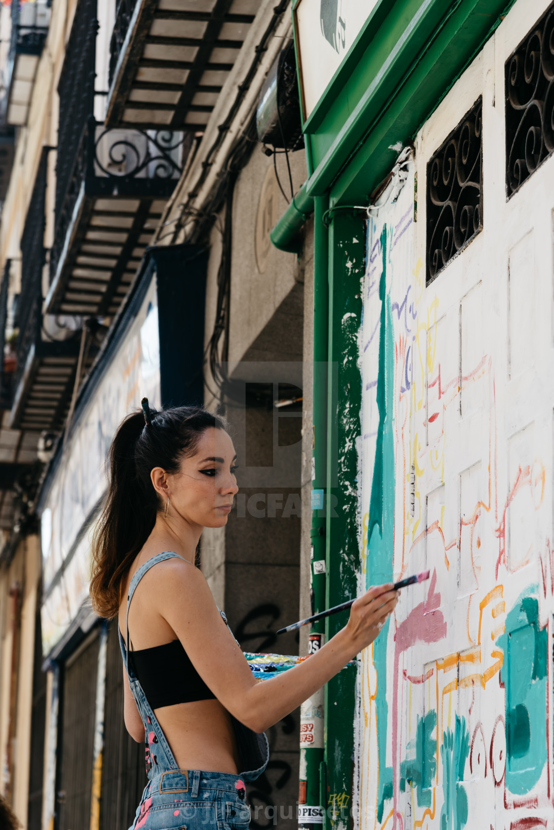 "Artist painting storefront in Malasana district in Madrid" stock image