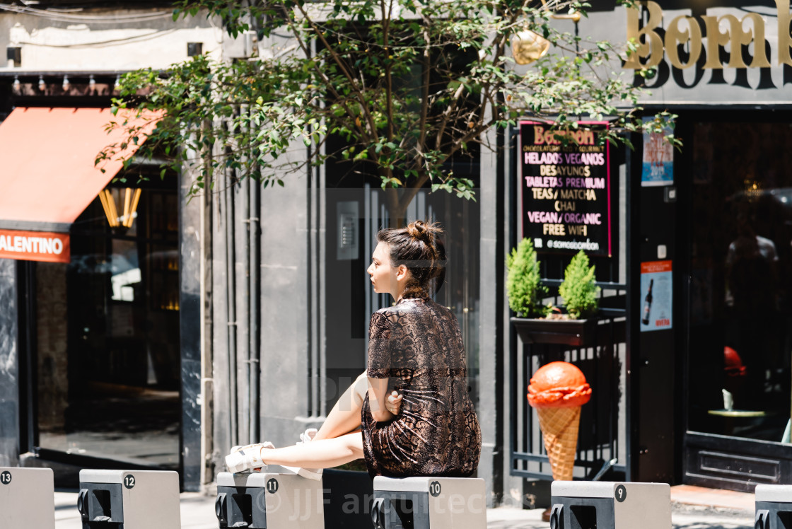 "Woman sitting on the street in Malasana district in Madrid" stock image