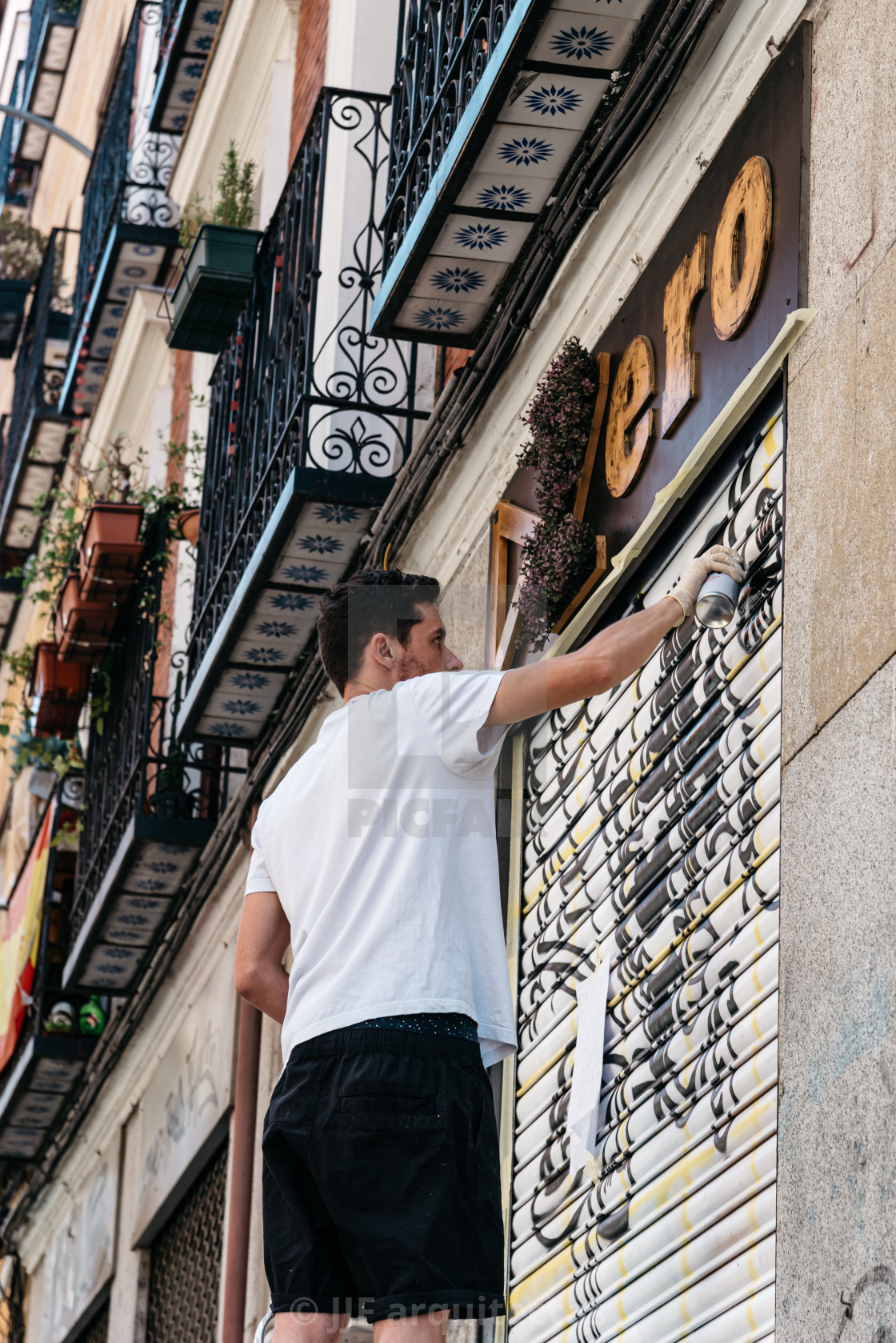 "Artist painting storefront in Malasana district in Madrid" stock image