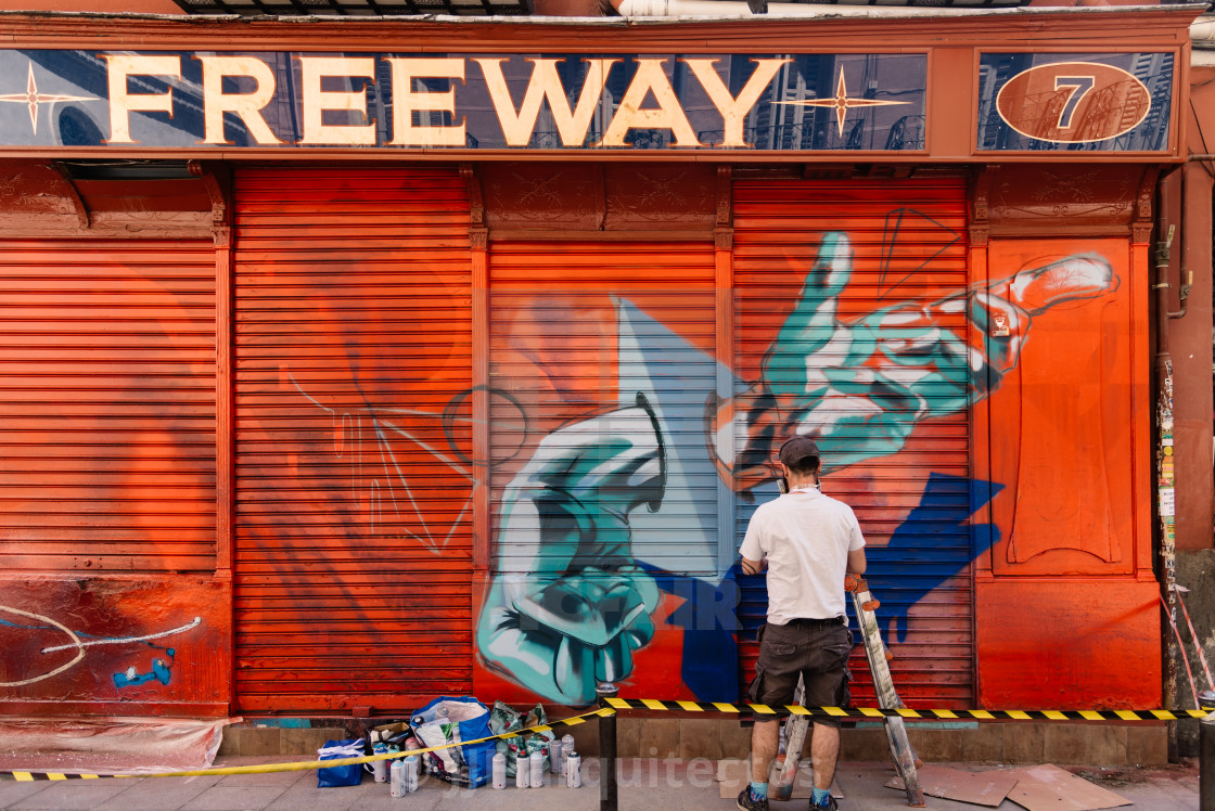 "Artist painting storefront in Malasana district in Madrid" stock image