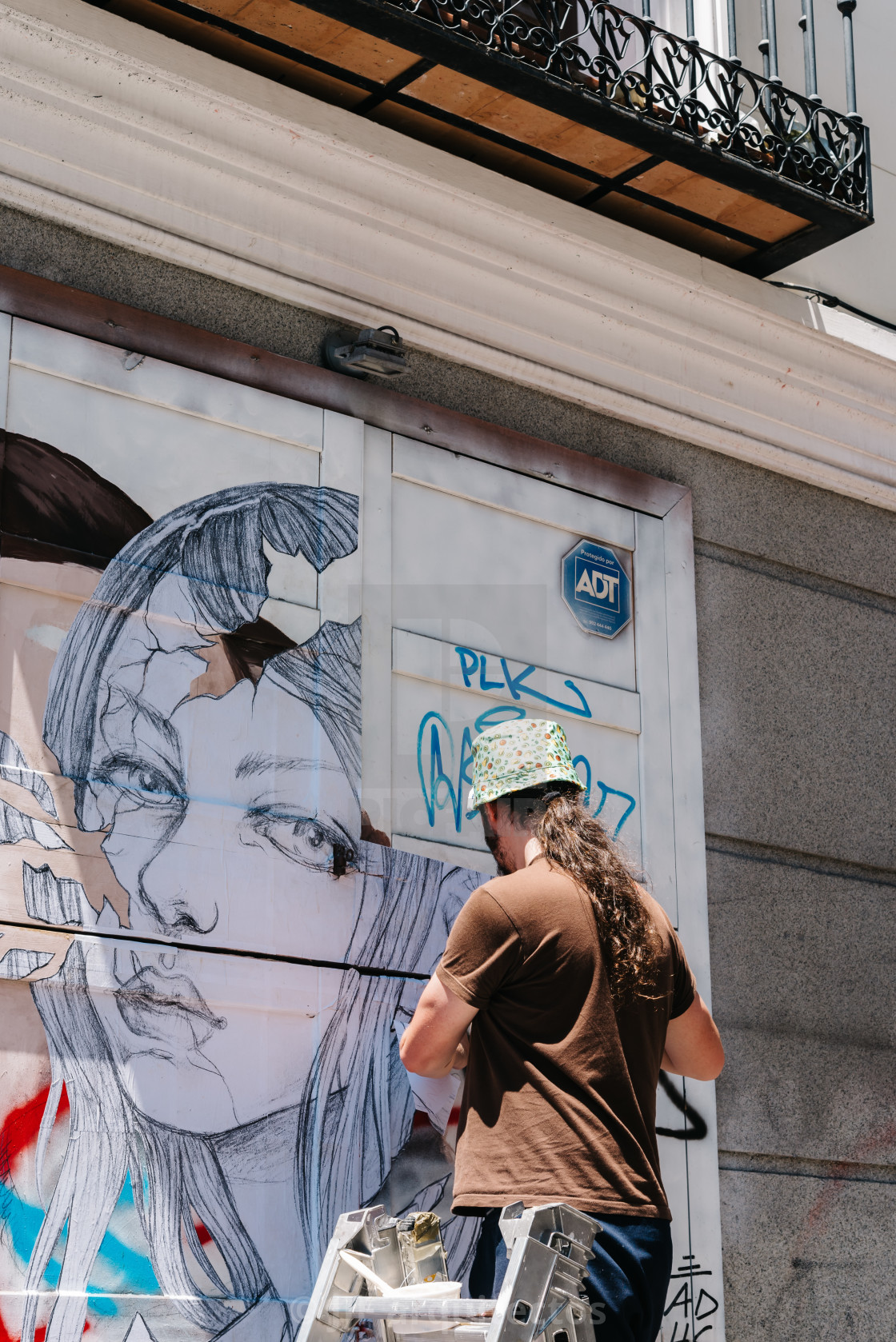 "Artist painting storefront in Malasana district in Madrid" stock image