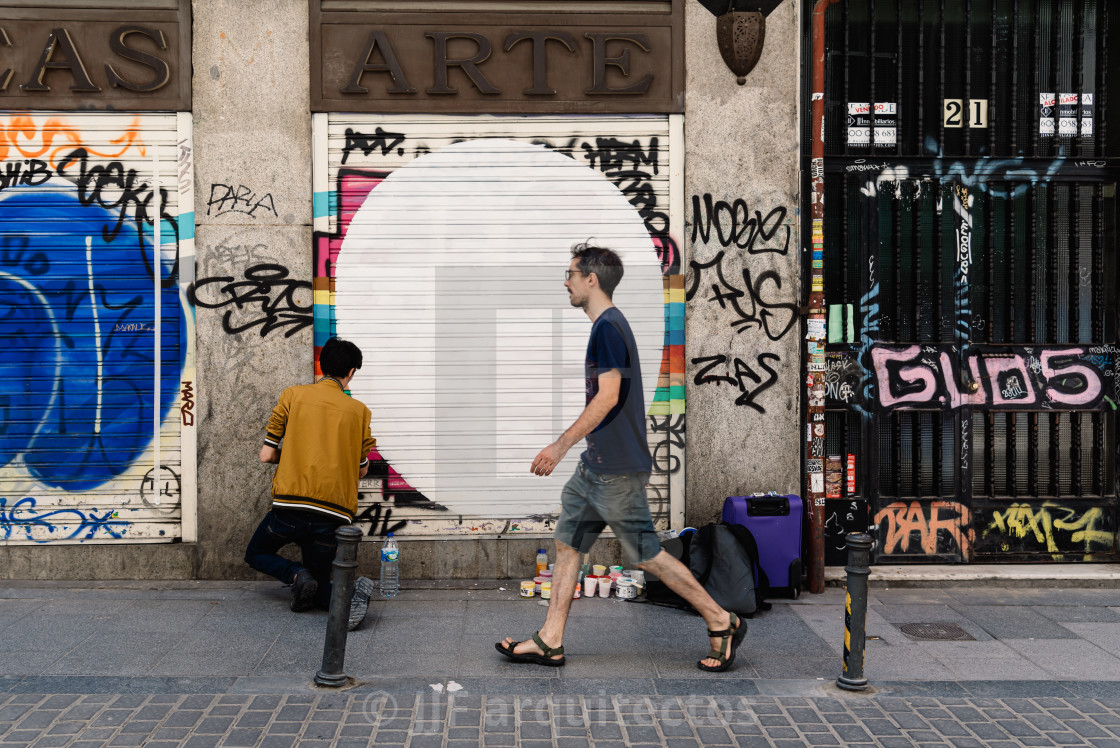 "Artist painting storefront in Malasana district in Madrid" stock image