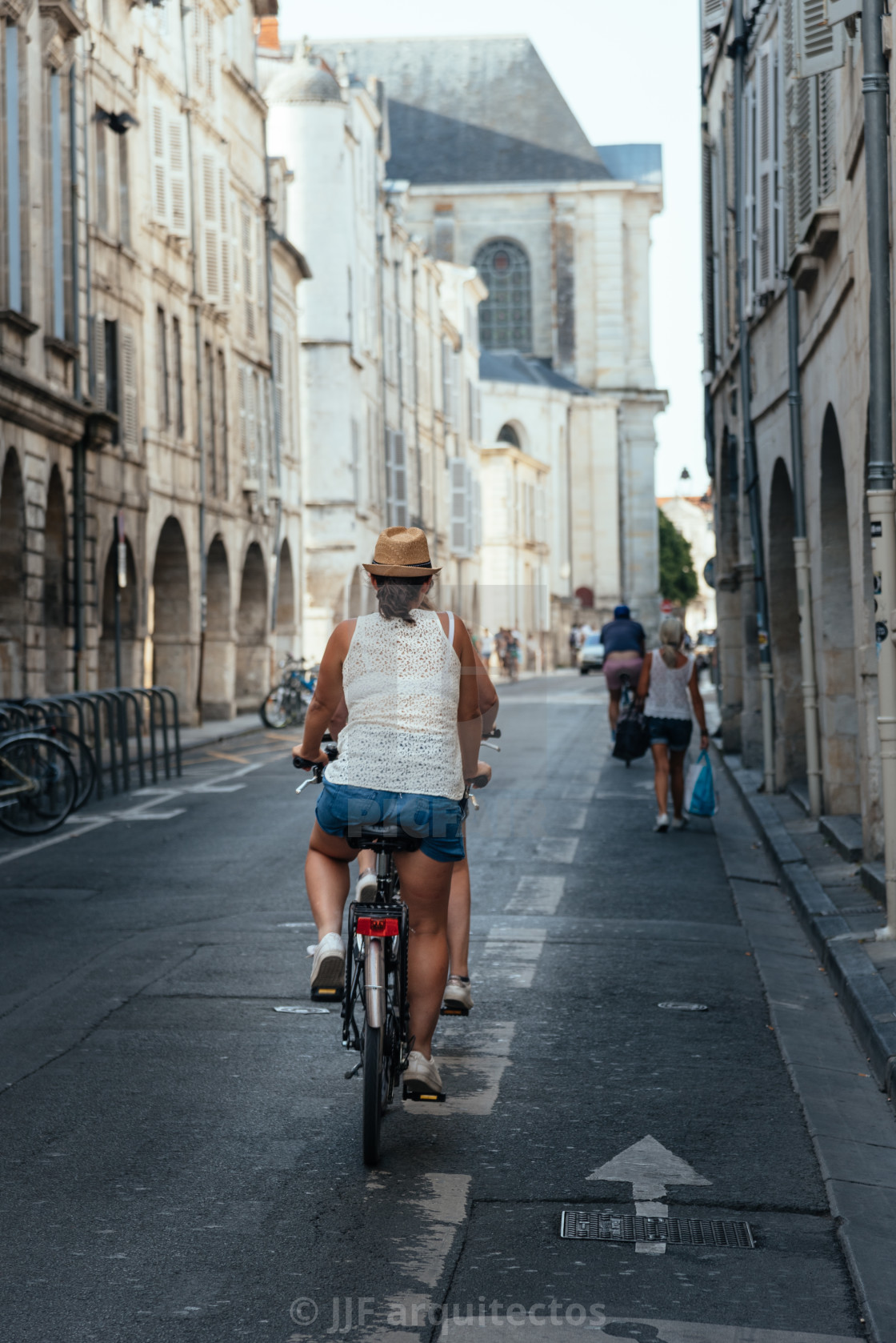 "Woman riding bicycle in the old town of La Rochelle" stock image