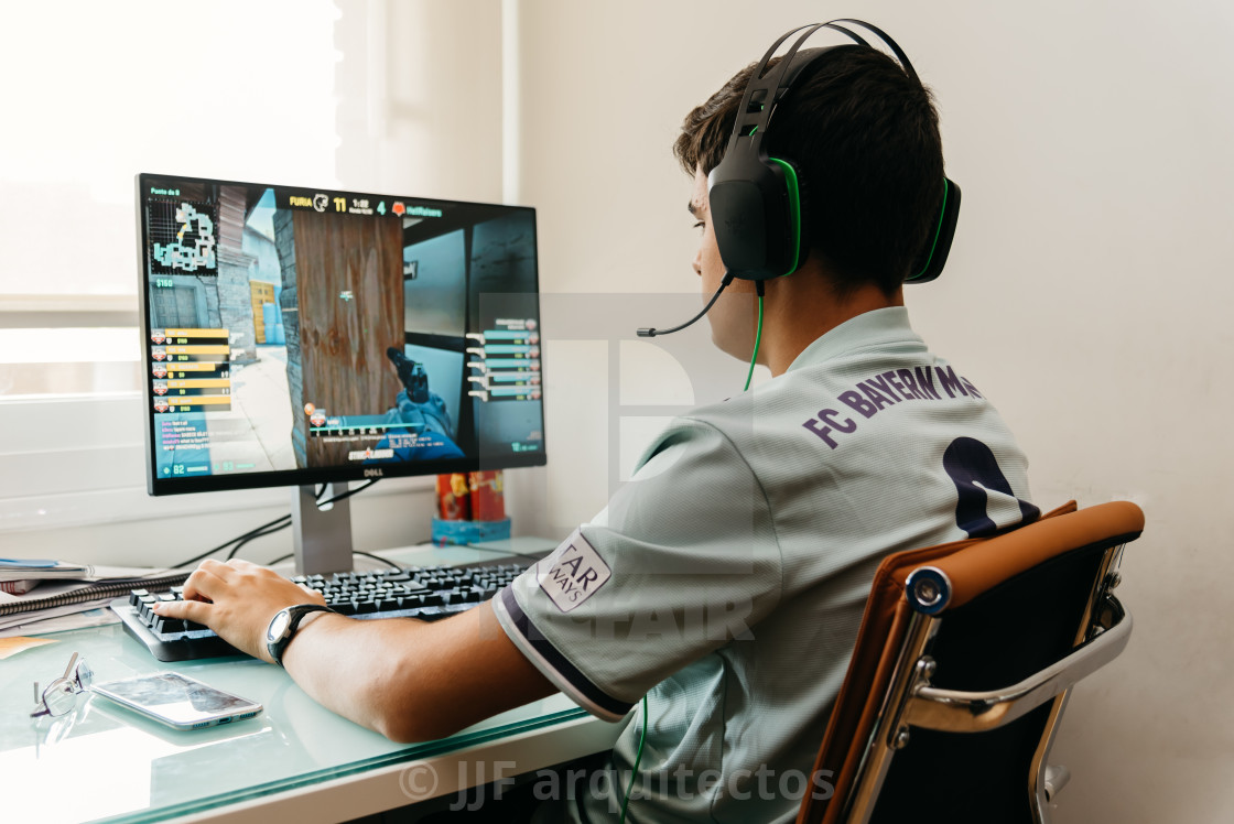 "Teenager playing CSGO video game on PC" stock image