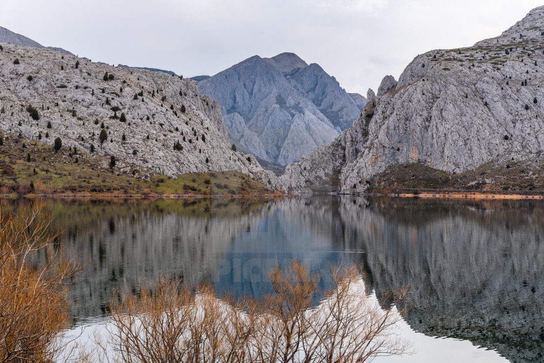 "Scenic view of mountains reflecting on water" stock image