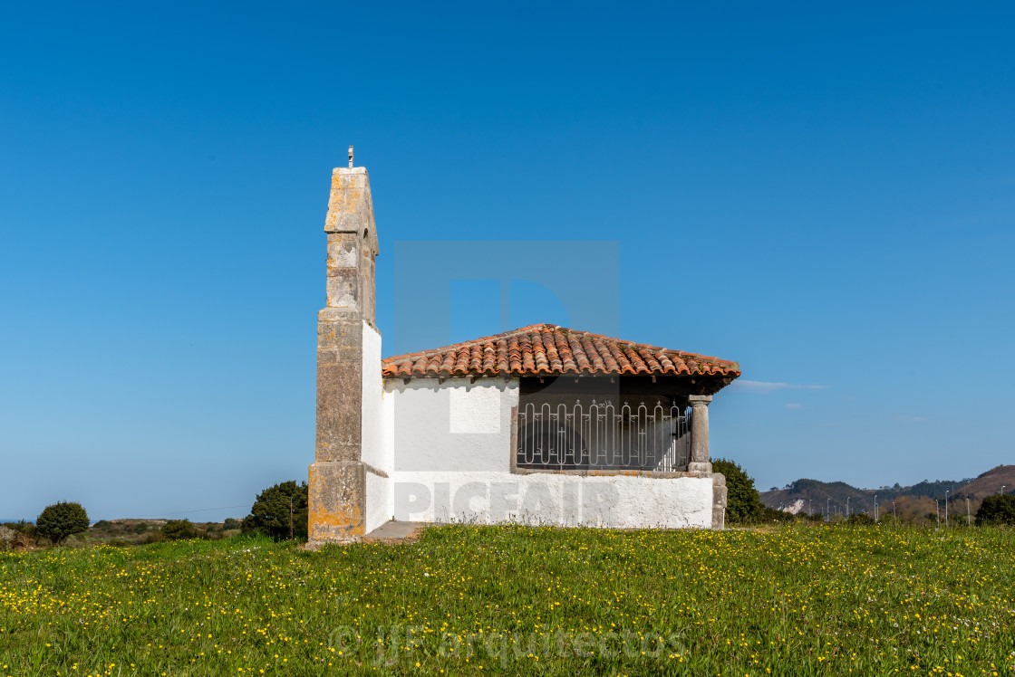 "Small chapel in meadow against the mountains" stock image